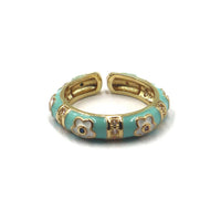 A gold-plated open cuff bangle bracelet with light turquoise enamel and white enamel floral motifs, shown on a plain white background.